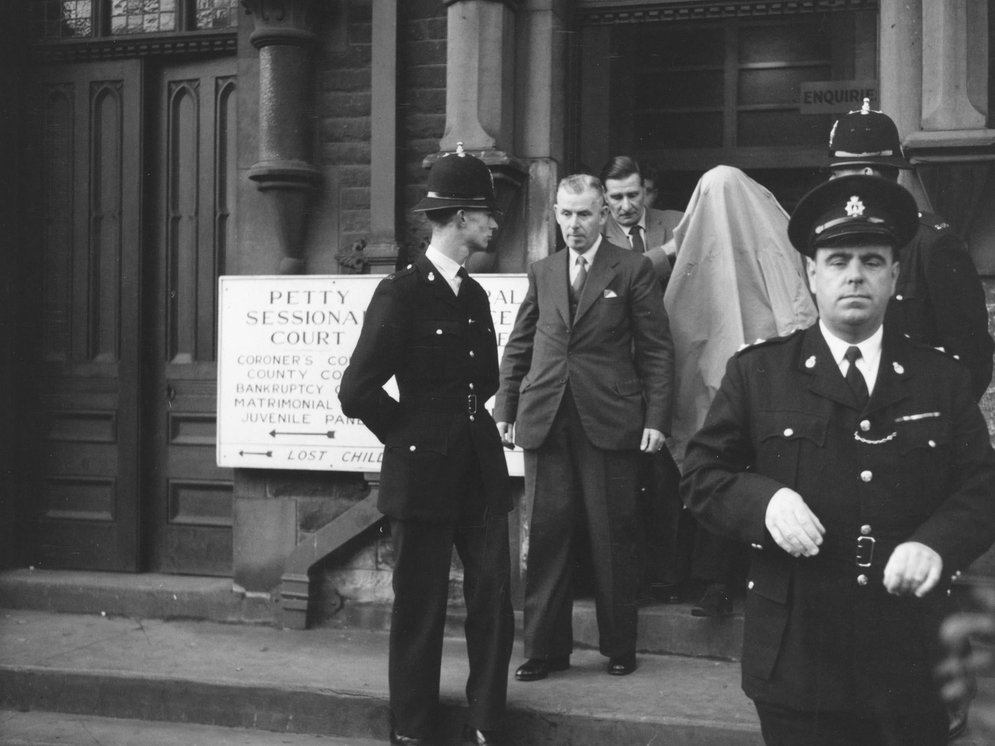 James Hanratty, covered by a blanket, leaves court where he is on trial for the A6 road murder of Michael John Gregsten. Hanratty was later convicted and executed for the murde