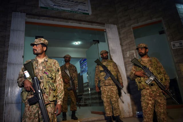 Pakistani soldiers stand guard at the entrance of a local hospital in the town of Sehwan on 17 February 2017,
