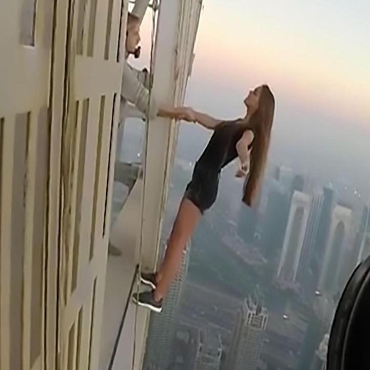 a woman falling off of a tall building Stock Photo