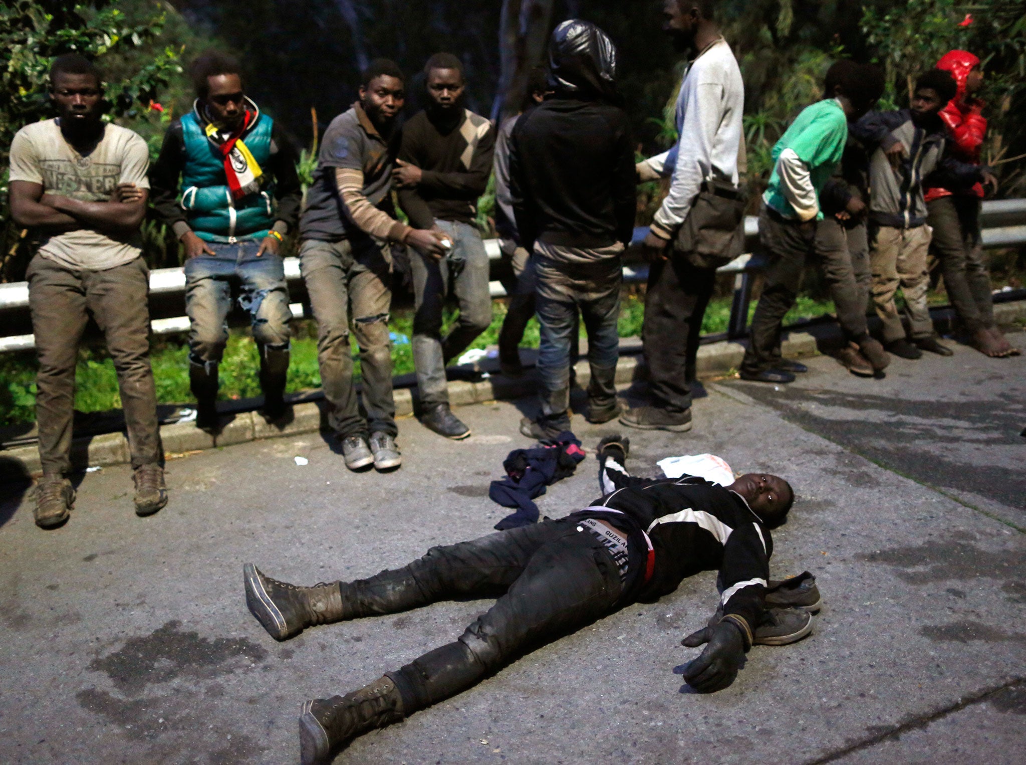 Migrants rest after storming a fence to enter the Spanish enclave of Ceuta, Spain, on 17 February