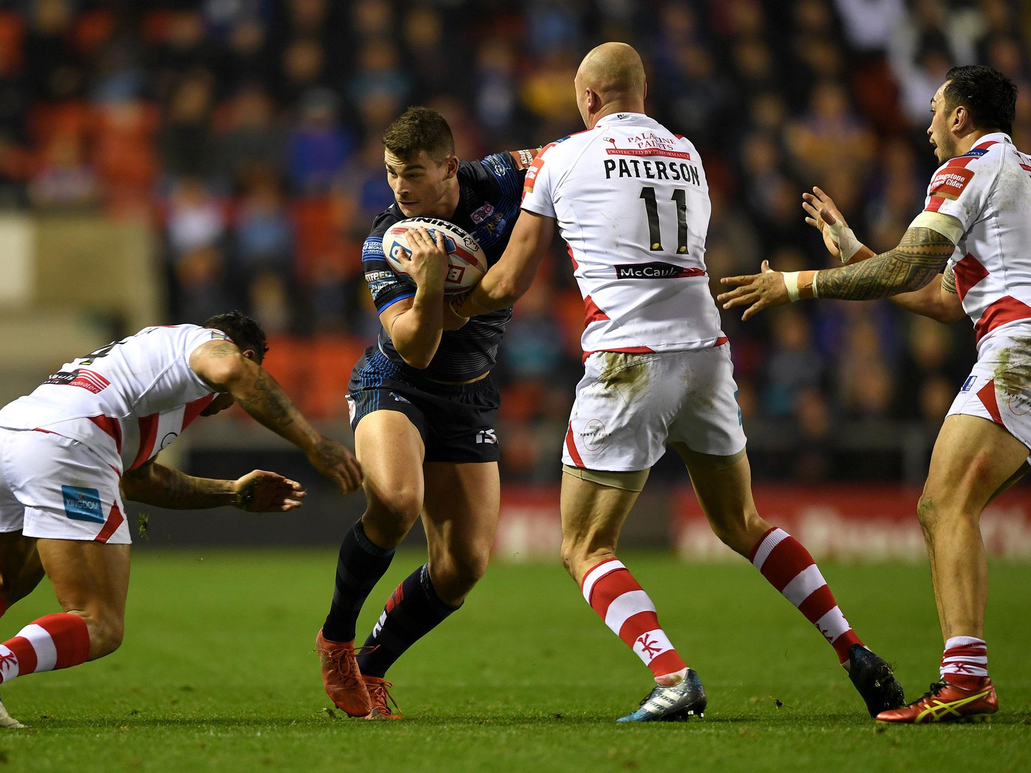 Stevie Ward of Leeds is tackled by Cory Paterson of Leigh