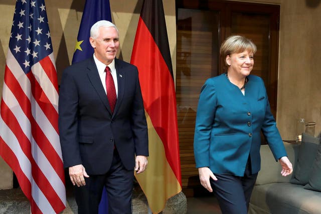 Angela Merkel walks with US Vice President Mike Pence before their meeting at the Munich Security Conference
