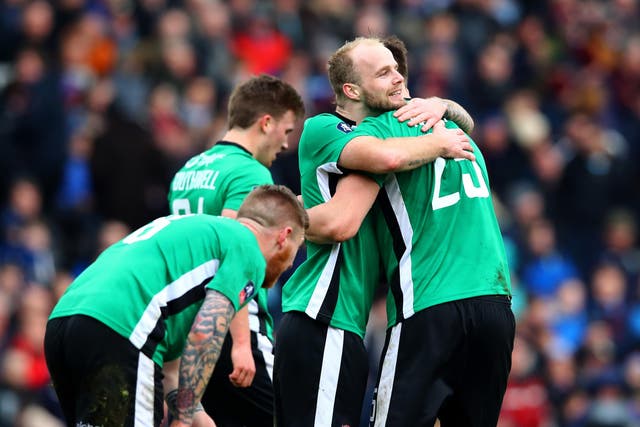 Sean Raggett is mobbed by his team-mates after scoring the winning goal