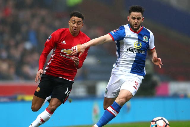Jesse Lingard and Craig Conway battle for the ball in the opening stages at Ewood Park