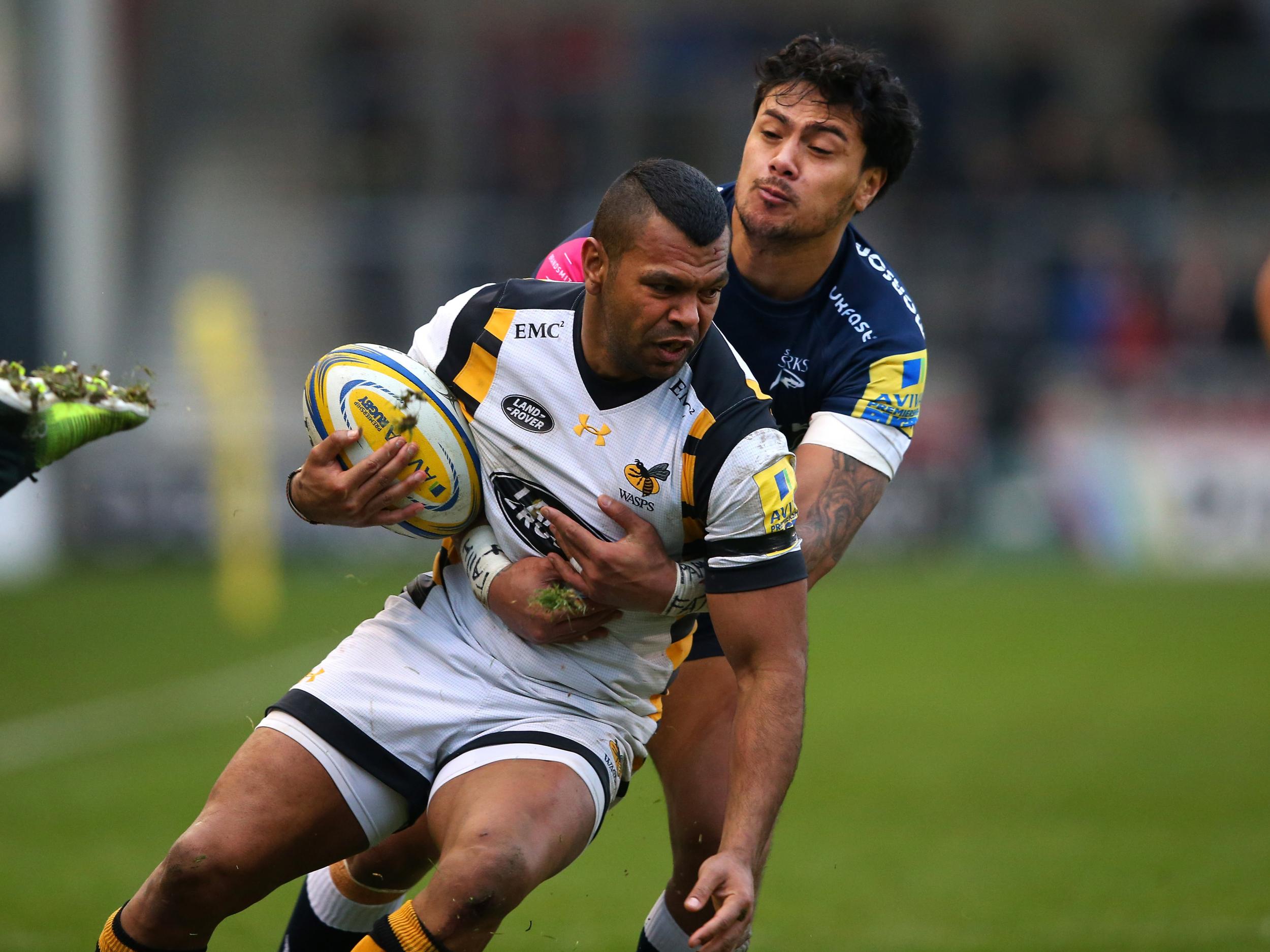 Kurtley Beale of Wasps is tackled by Denny Solomona