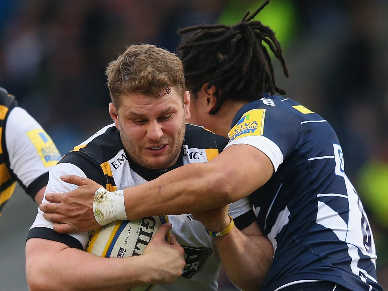 Thomas Young of Wasps is tackled by TJ Ioane