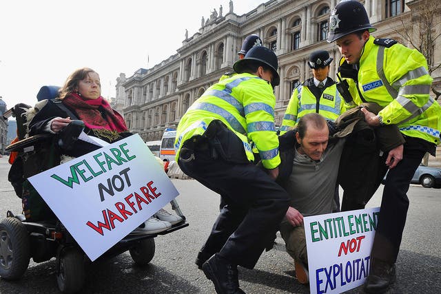 Police remove disabled protesters to the side of the road Whitehall, London where they were demonstrating about Government welfare policy and provision
