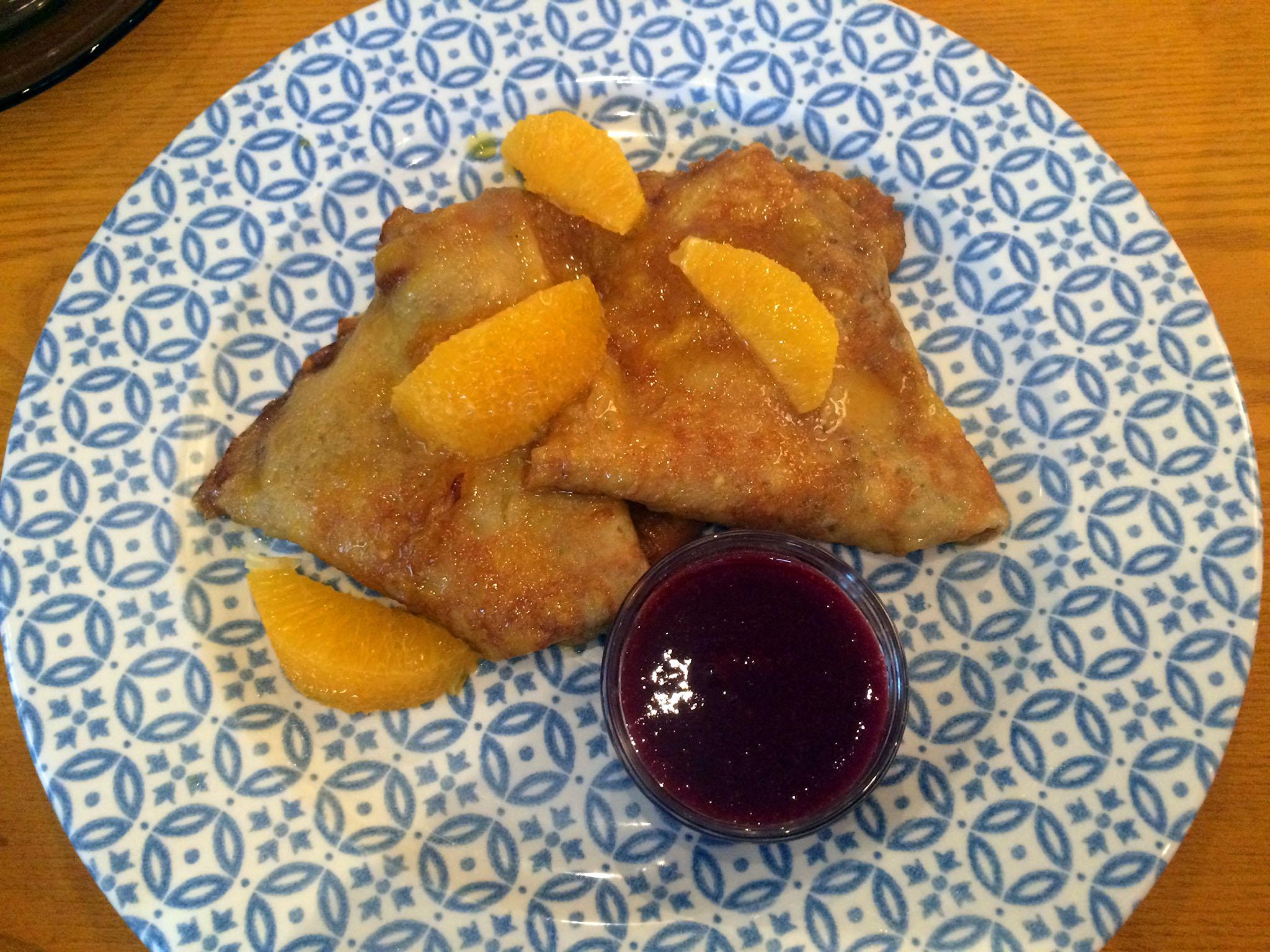Richly sweet, the Crêpe Suzette comes topped with oranges and served with a raspberry sauce