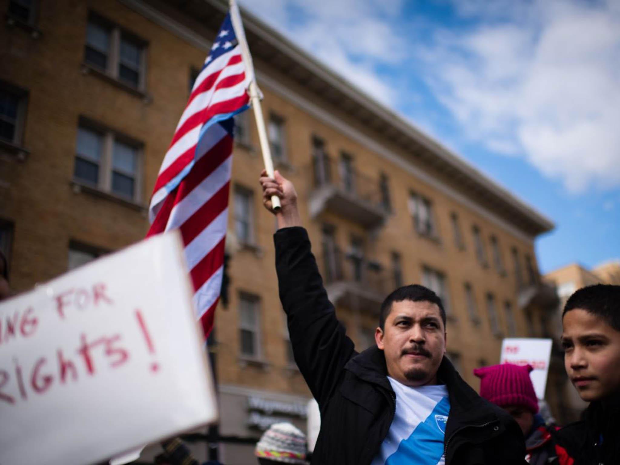 Marcos Latin, 34, carries the Guatemalan and US flags on “A Day Without Immigrants.” Latin, originally from Guatemala and resident in the United States for 12 years, walked with his son, Mauricio Amaya, 11 years old