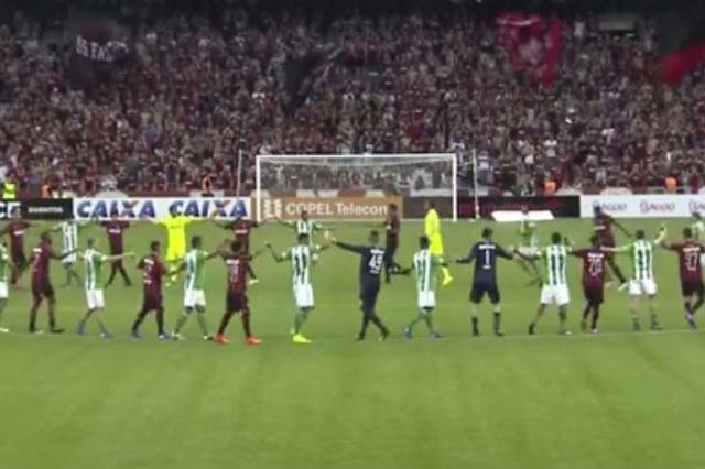 Coritiba and Atletico players salute the crowd as their derby is postponed