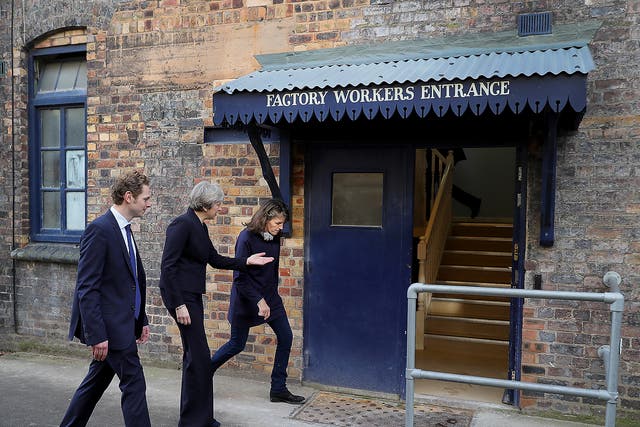 British Prime Minister Theresa May is escorted by Emma Bridgewater and Stoke Central by-election candidate Jack Brereton, as she arrives at the Emma Bridgewater pottery factory in Hanley, Stoke-On-Trent, England
