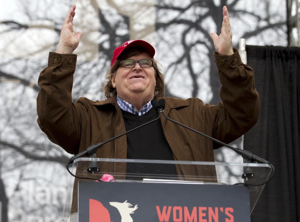Film director Michael Moore speaks to the crowd during a women's march rally