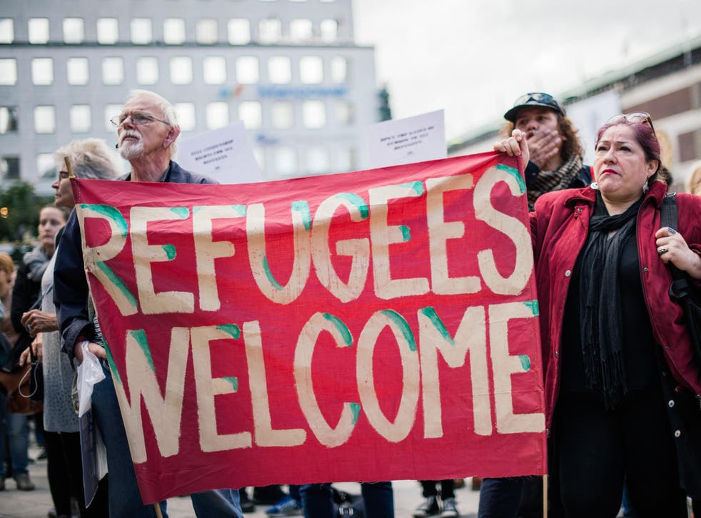 People hold a 'refugees welcome' banner at a demonstration in Stockholm, Sweden