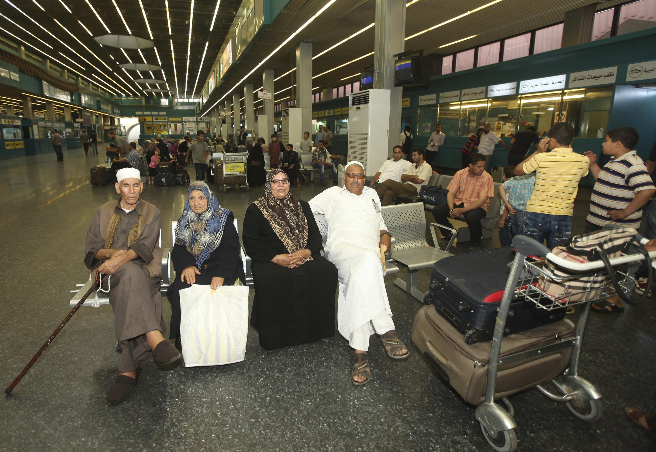 Passengers wait for flights in a hall at Tripoli International Airport on June 5, 2012.