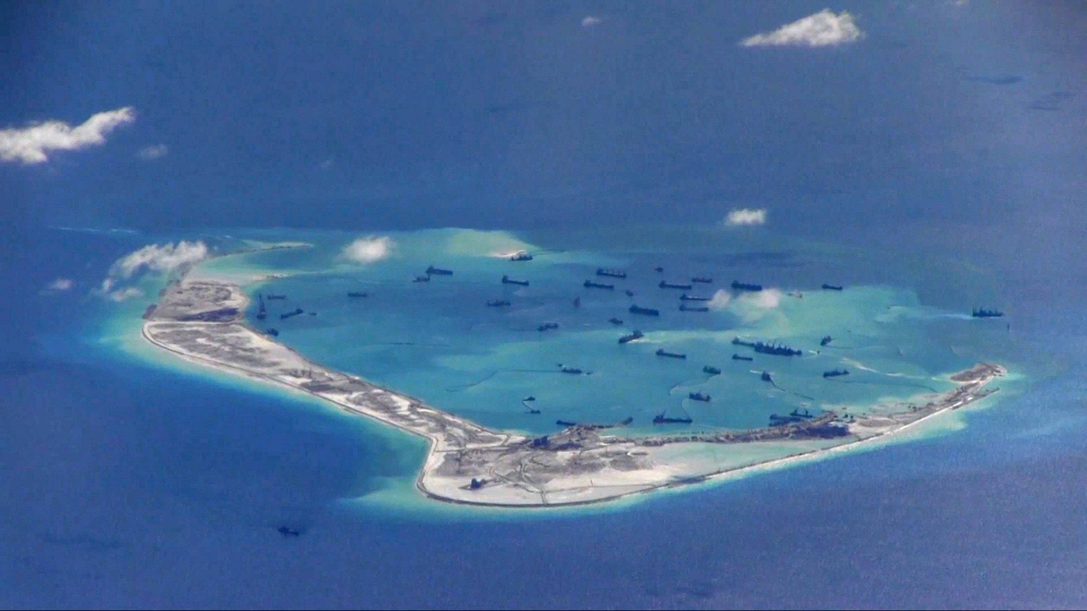Chinese dredging vessels are purportedly seen in the waters around Mischief Reef in the disputed Spratly Islands in the South China Sea in this still image from video taken by a P-8A Poseidon surveillance aircraft provided by the United States Navy