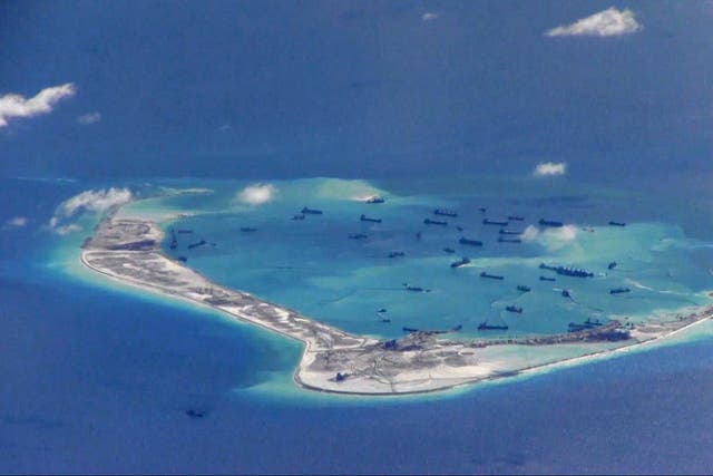 Chinese dredging vessels are purportedly seen in the waters around Mischief Reef in the disputed Spratly Islands in the South China Sea in this still image from video taken by a P-8A Poseidon surveillance aircraft provided by the United States Navy