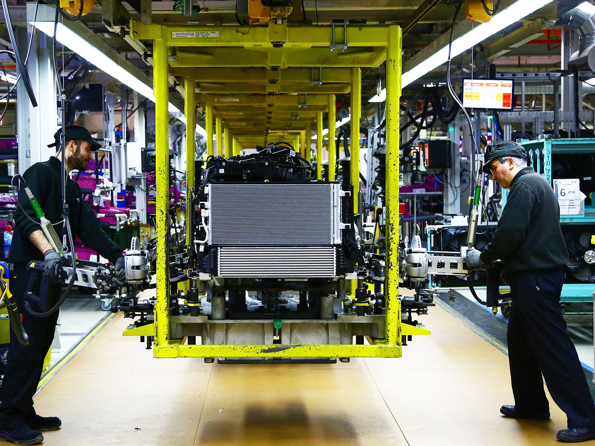 An engine is 'dressed' on the assembly line at the car production plant in Oxford