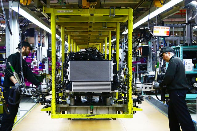A Mini engine is 'dressed' on the assembly line at the BMW Mini car production plant in Oxford