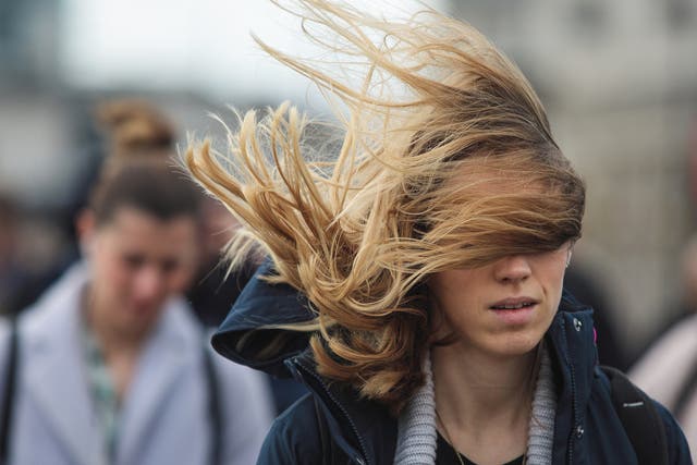 A commuter's hair blows in the wind as they cross London Bridge during Storm Doris