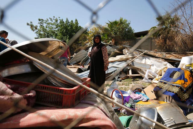 A woman from the Arab Jahalin Bedouin community stands amidst the debris of homes in the West Bank Bedouin camp of al-Khan al-Ahmar on April 7, 2016