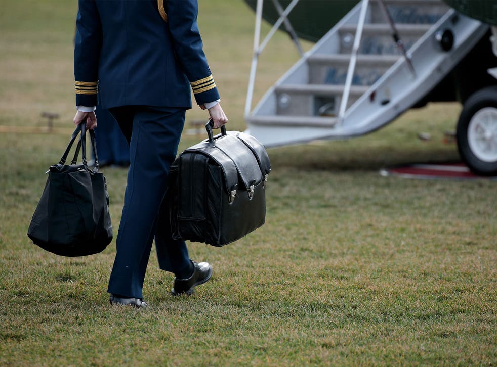 A military aide carries the alleged 'football,' a case with the launch codes for nuclear weapons, toward Marine One as US President Donald Trump prepares to take off on the South Lawn of the White House
