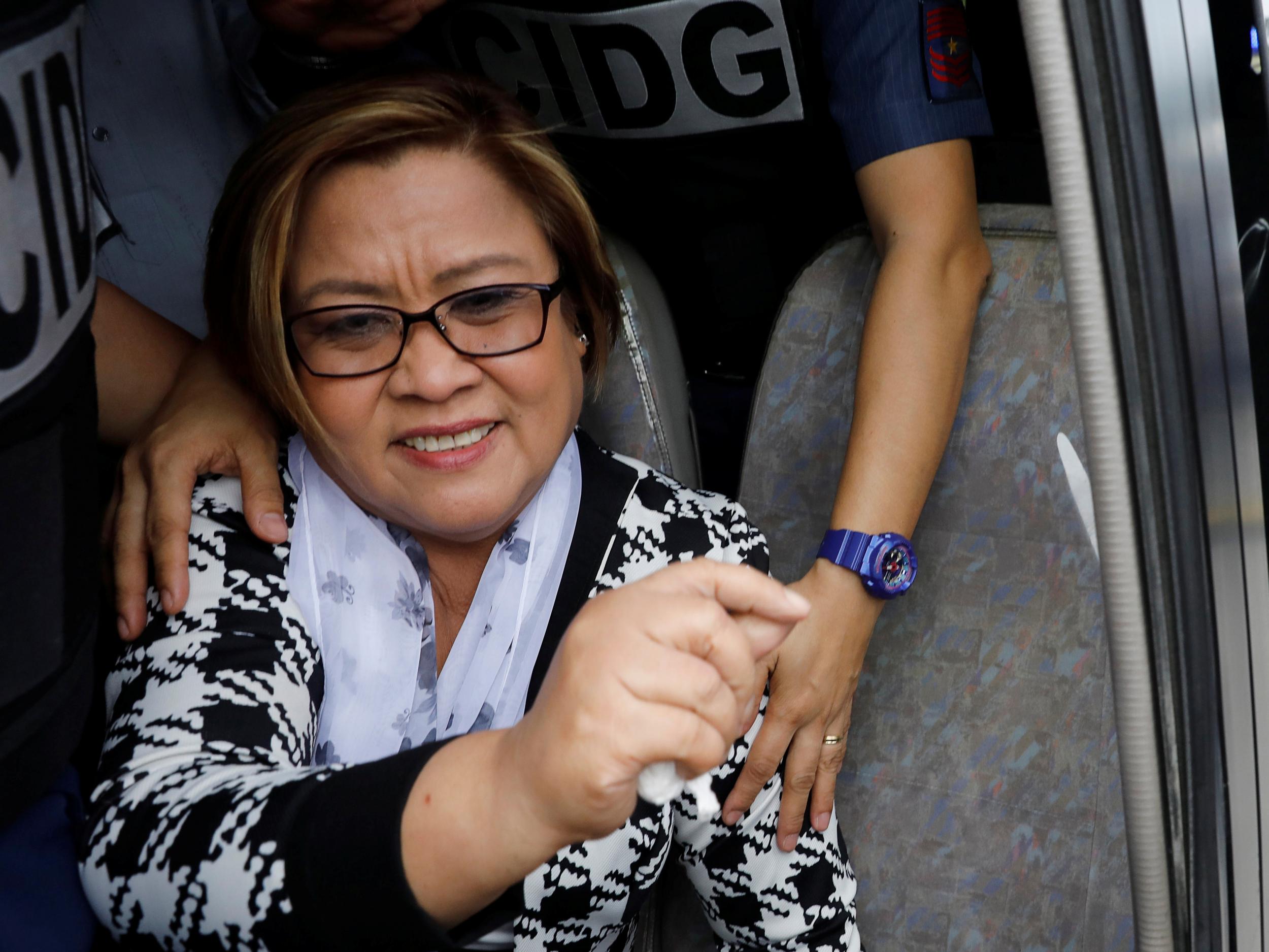 Policemen guard Philippine Senator Leila De Lima inside a a police van after appearing at a Muntinlupa court on drug charges in Muntinlupa, Metro Manila