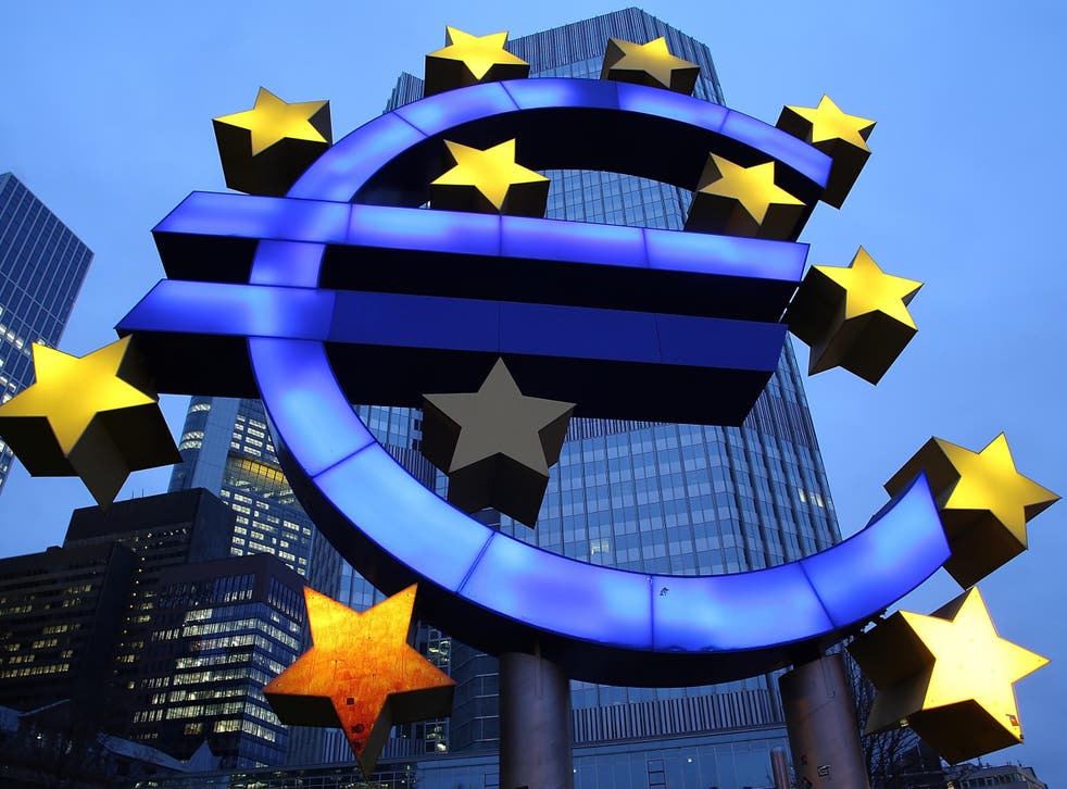 The symbol of the Euro, the currency of the Eurozone, stands illuminated outside a bank