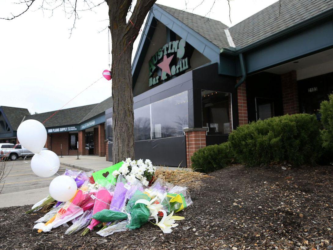 Flowers lie outside the bar where a gunman reportedly asked two Indian men about their visa status before shooting them