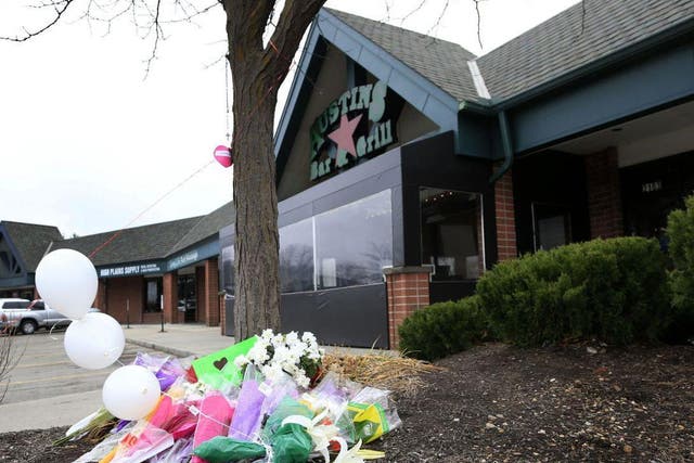 Flowers lie outside the bar where a gunman reportedly asked two Indian men about their visa status before shooting them