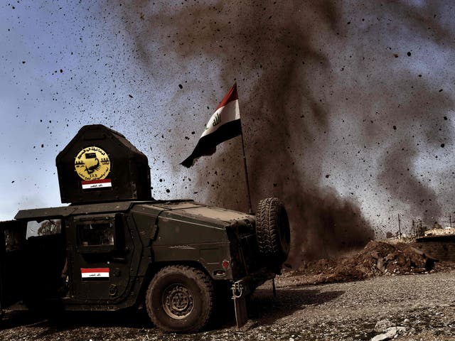 An explosion hits near a vehicle belonging to Iraq's elite Rapid Response Division during the assault to retake Mosul on 25 February