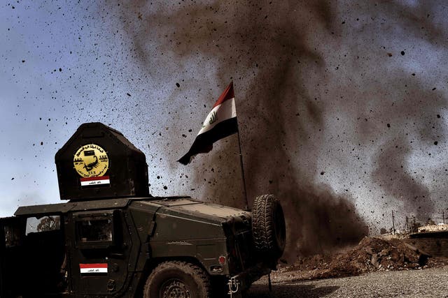 An explosion hits near a vehicle belonging to Iraq's elite Rapid Response Division during the assault to retake Mosul on 25 February