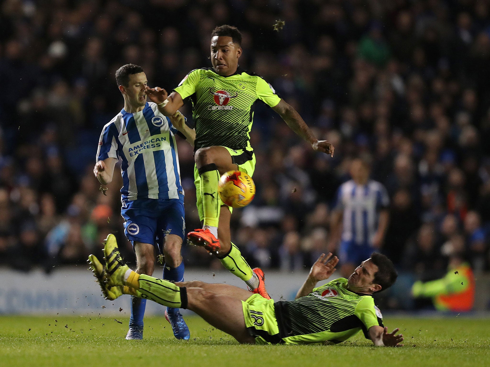 Reading's Yann Kermorgant and Liam Moore attempt to get the ball ahead of Brighton and Hove Albion's Jamie Murphy