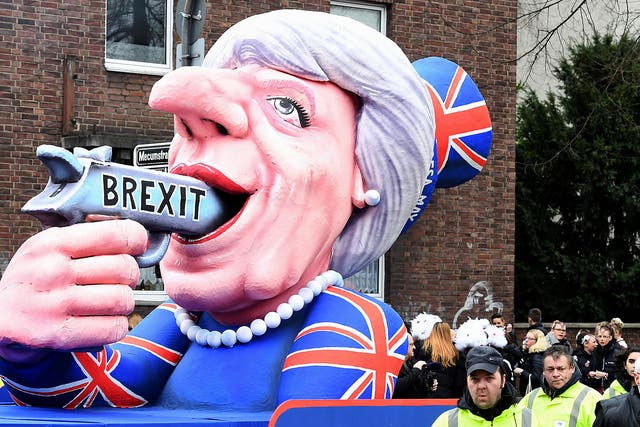 A carnival float depicting British Prime Minister Theresa May pointing a gun to her with the lettering 'Brexit' takes part in the traditional 'Rose Monday' carnival parade in Duesseldorf, western Germany
