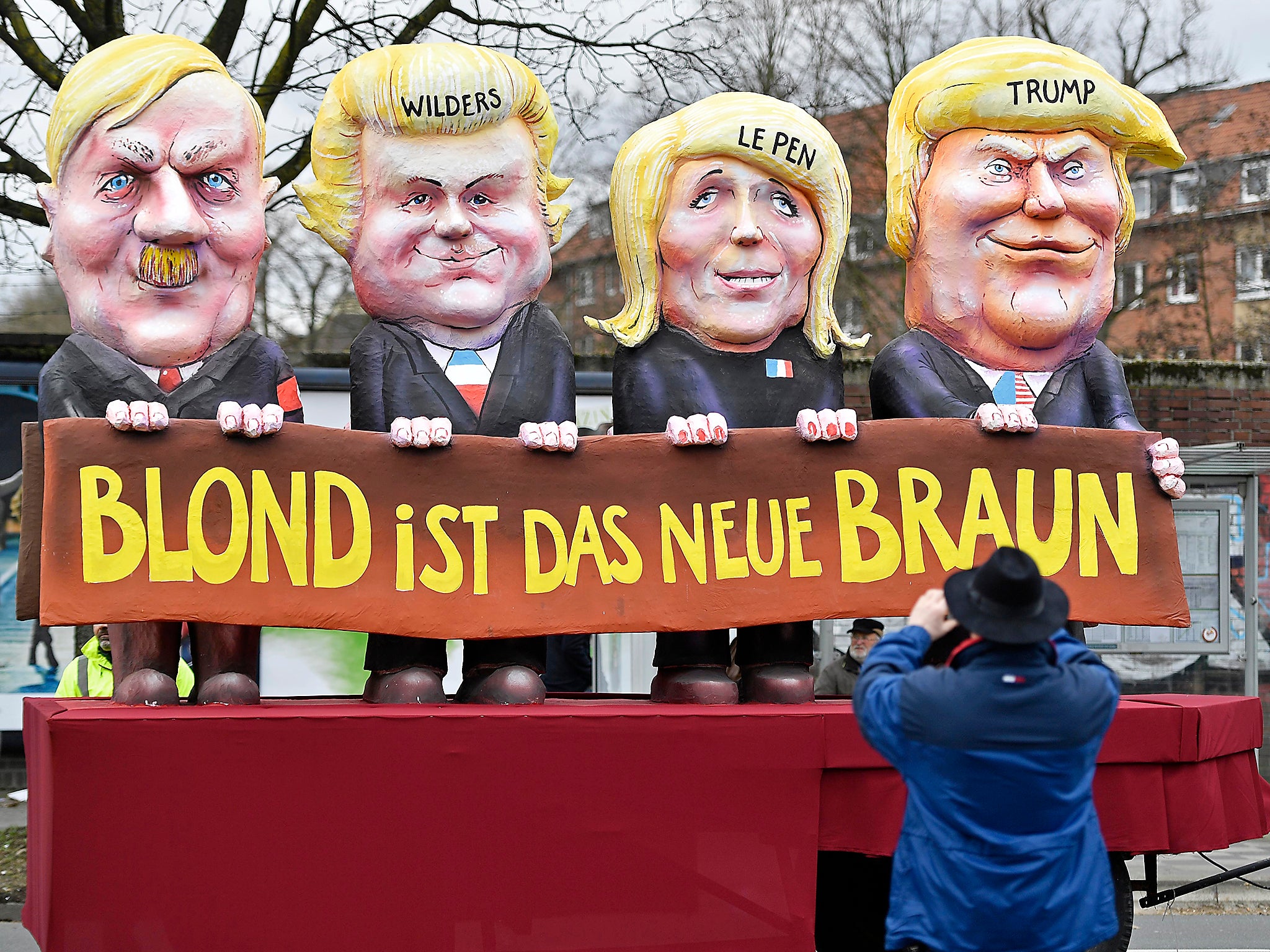 A reveller takes a picture of a carnival float depicting US president Donald Trump with Marine Le Pen, Geert Wilders and Adolf Hitler, reading 'blonde is the new brown'
