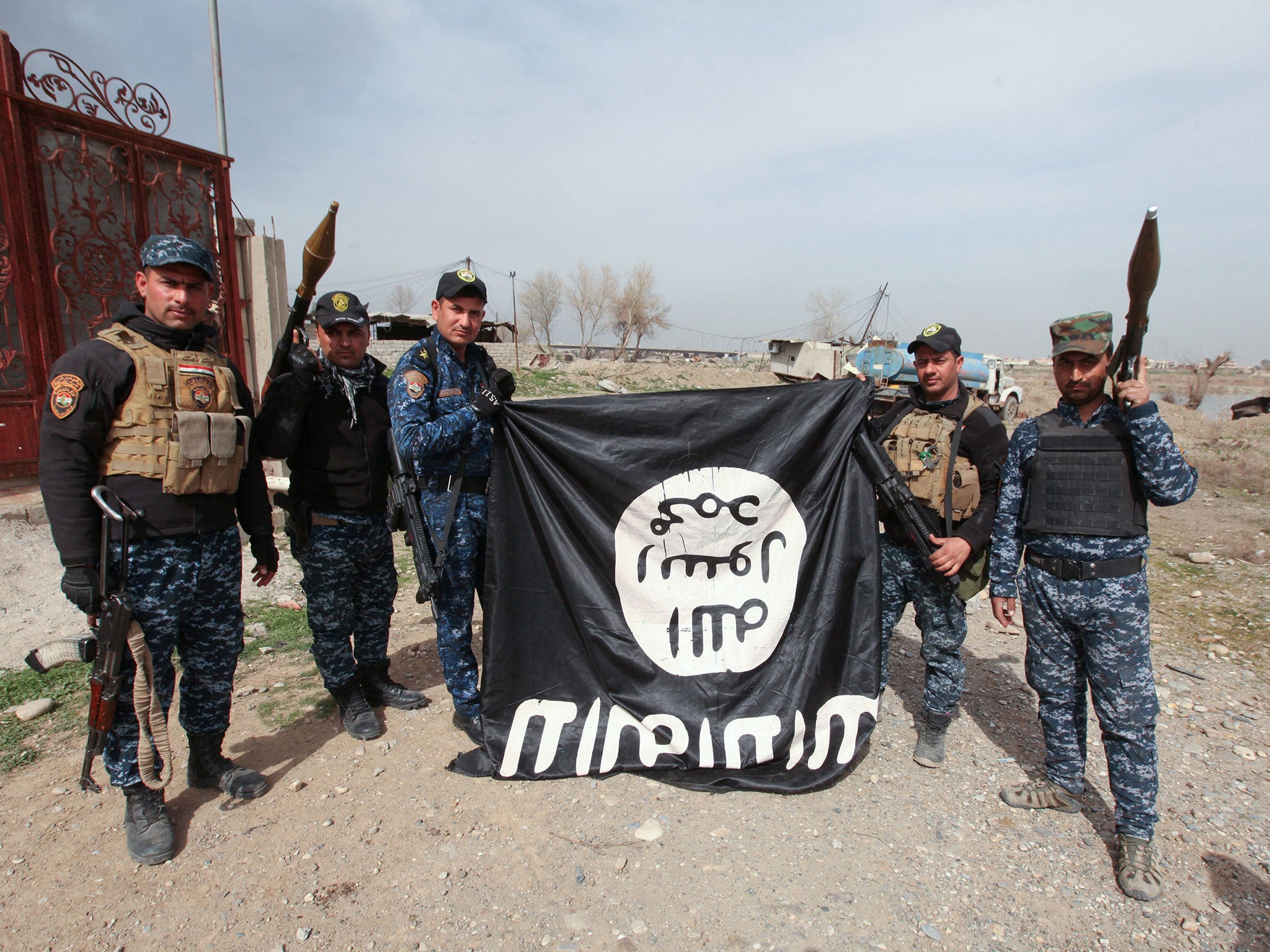 Members of the Iraqi security forces with an Isis flag they pulled down during a battle with militants in al-Josaq district, western Mosul, on Monday