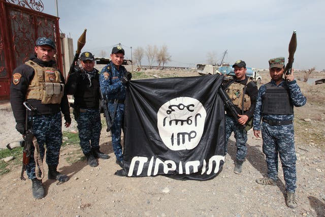 Members of the Iraqi security forces with an Isis flag they pulled down during a battle with militants in al-Josaq district, western Mosul, on Monday