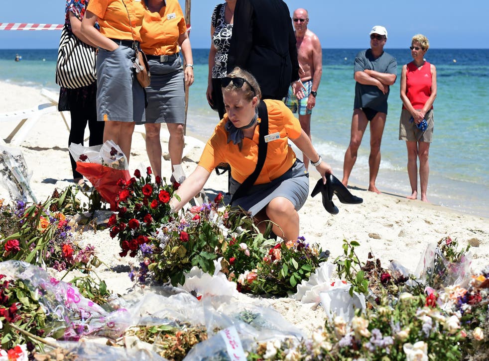 Tourists lay flowers in memory of those killed by a jihadist gunman on the beach in front of the Riu Imperial Marhaba Hotel in Tunisia