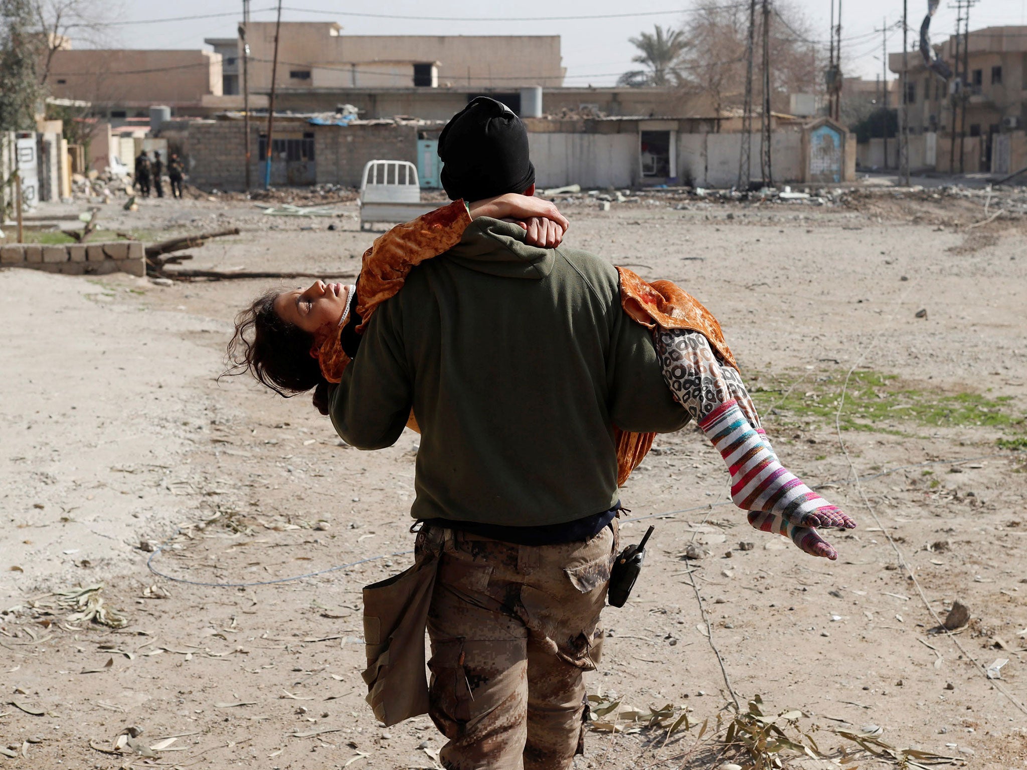 An Iraqi soldier carries a woman injured during a battle between Iraqi forces and Isis fighters in Mosul today