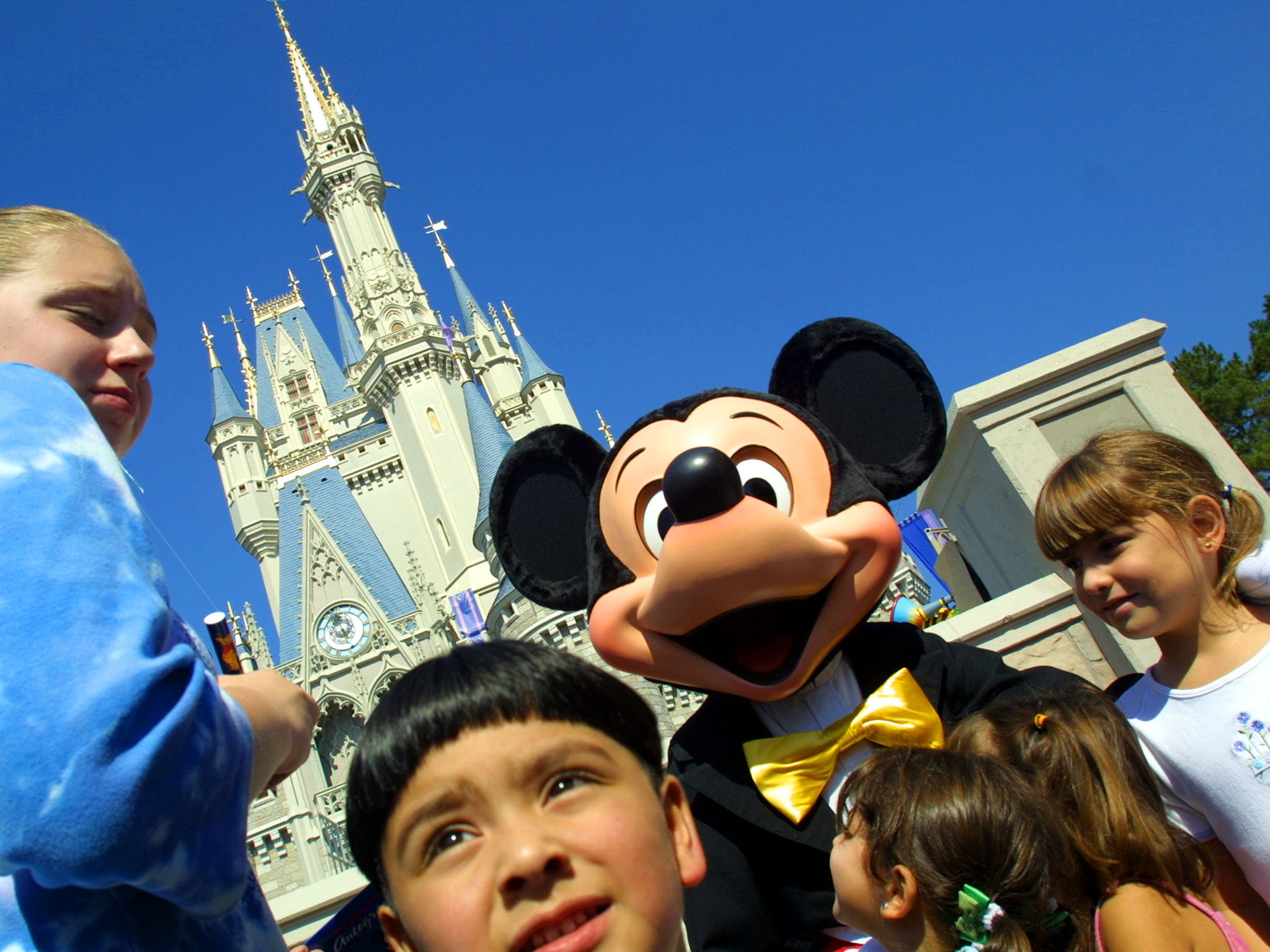 Mickey Mouse greets children in front of Cinderella's Castle at Magic Kingdom in  Florida - one of the US destinations that has seen a significant drop in flight searches