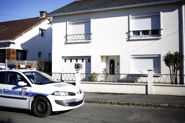 A police car parked outside the house belonging to the missing Troadec family in Orvault