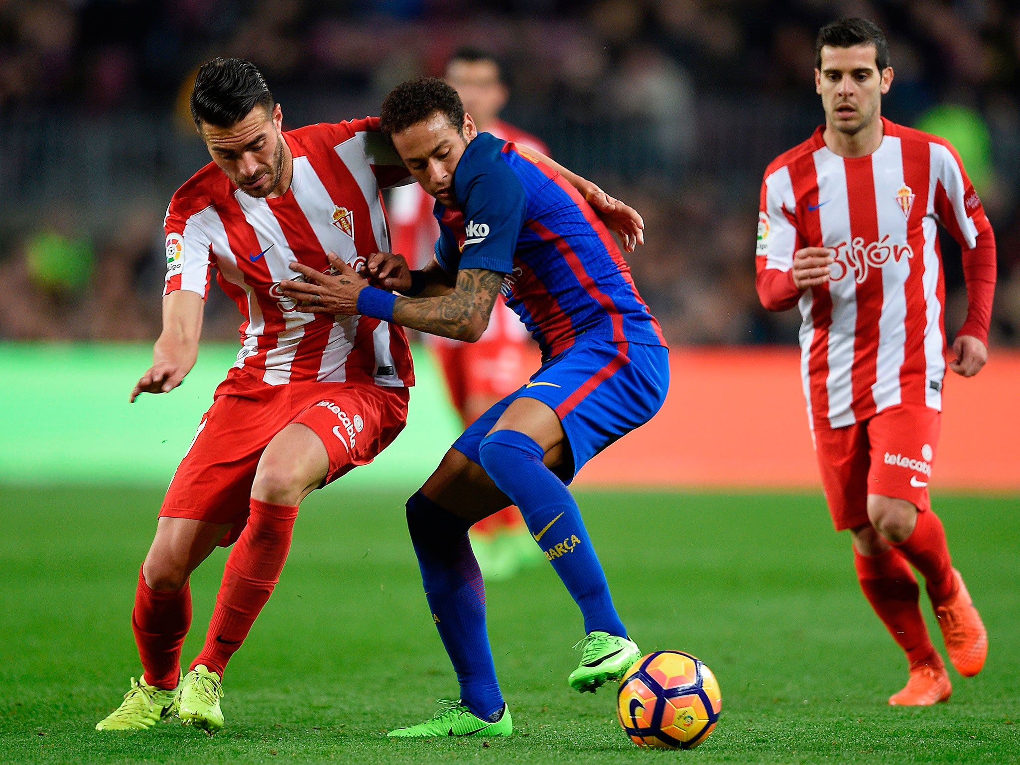 Neymar vies with Sporting Gijon's midfielder Xavi Torres