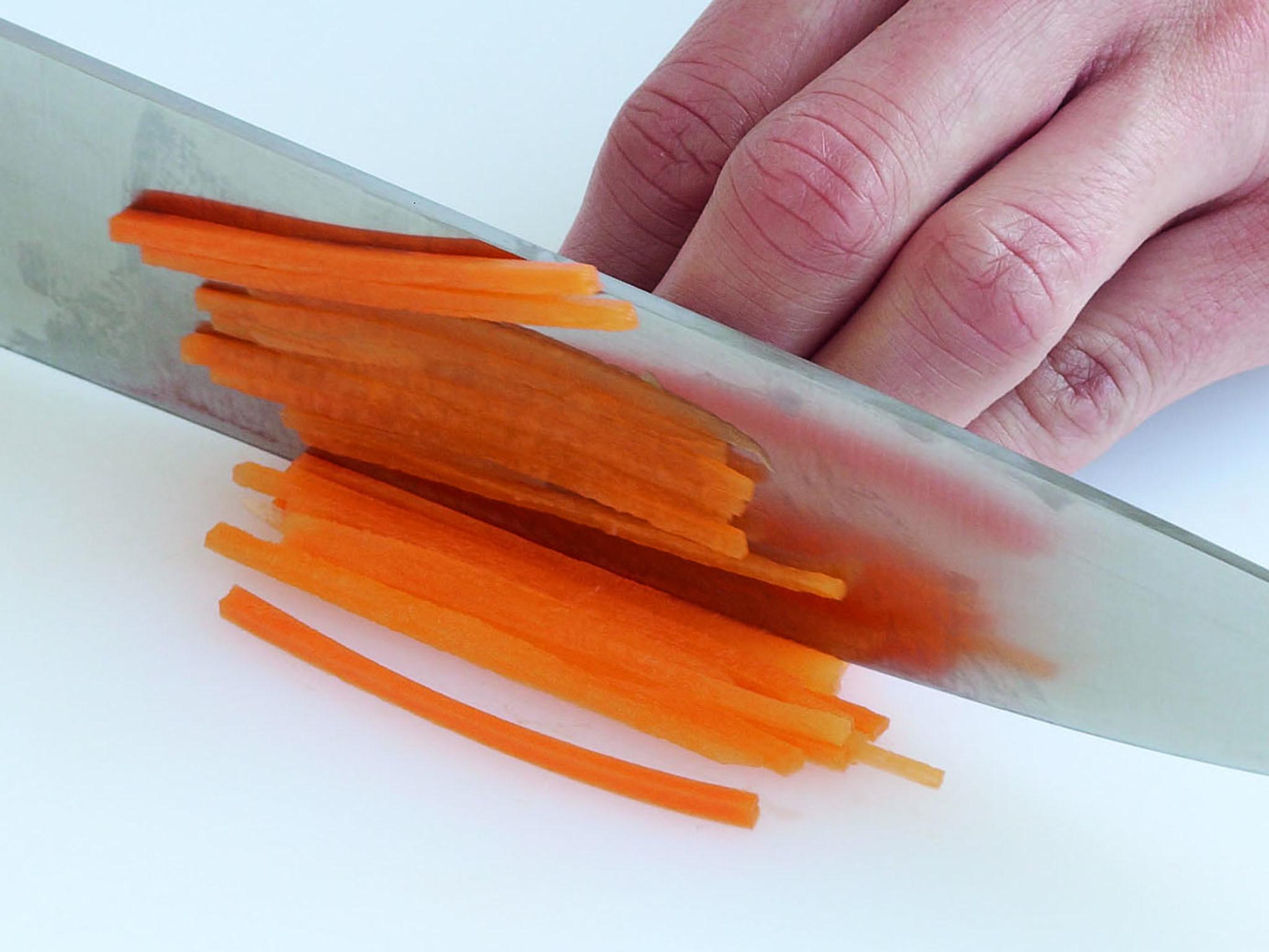 Cut the blocked carrot into very thin slices (1–2mm thick) and stack them neatly. Slice through the carrot as uniformly as possible to create julienne