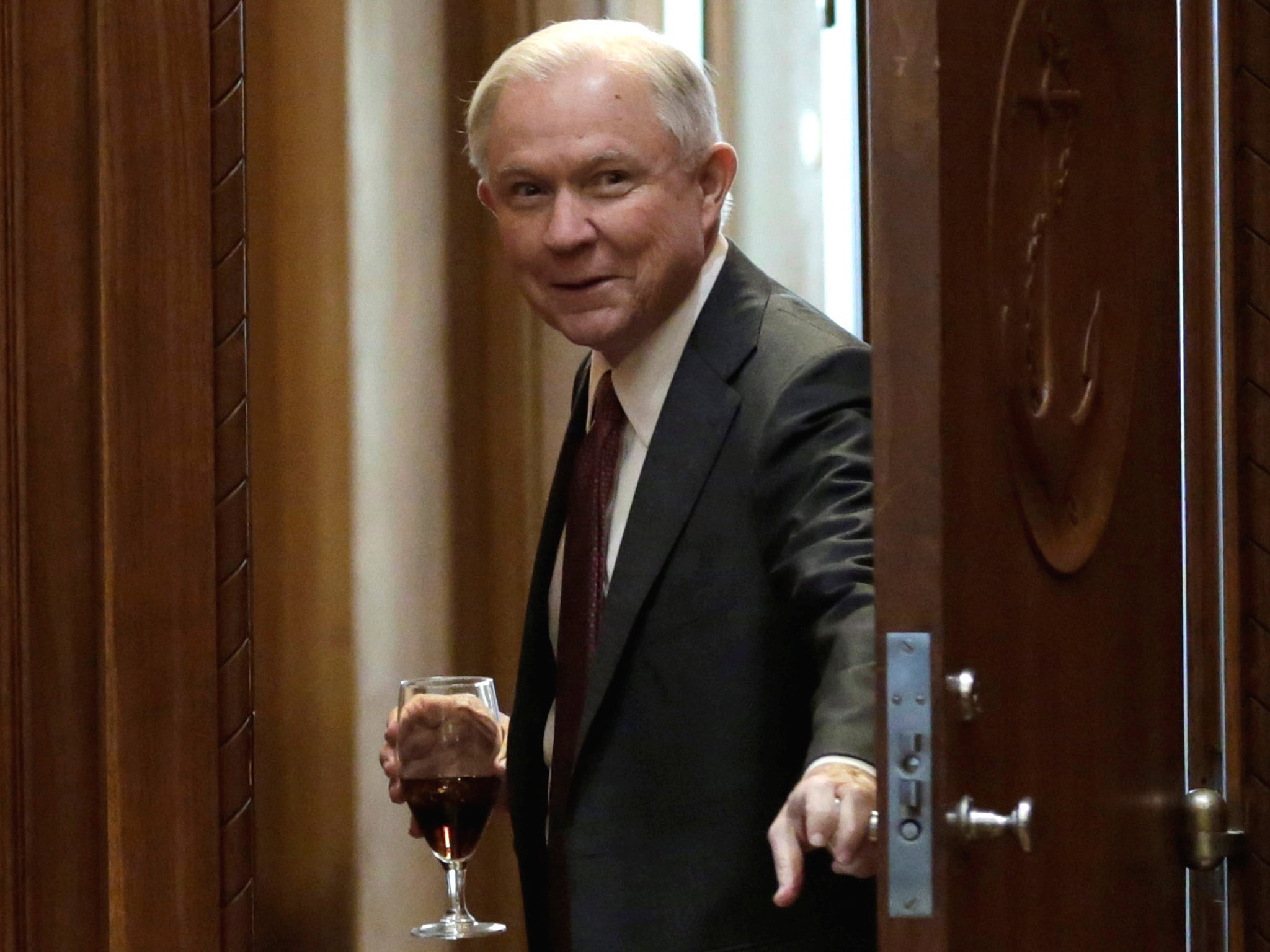 Attorney General Jeff Sessions opens a door before his first meeting with heads of federal law enforcement components at the Justice Department in Washington