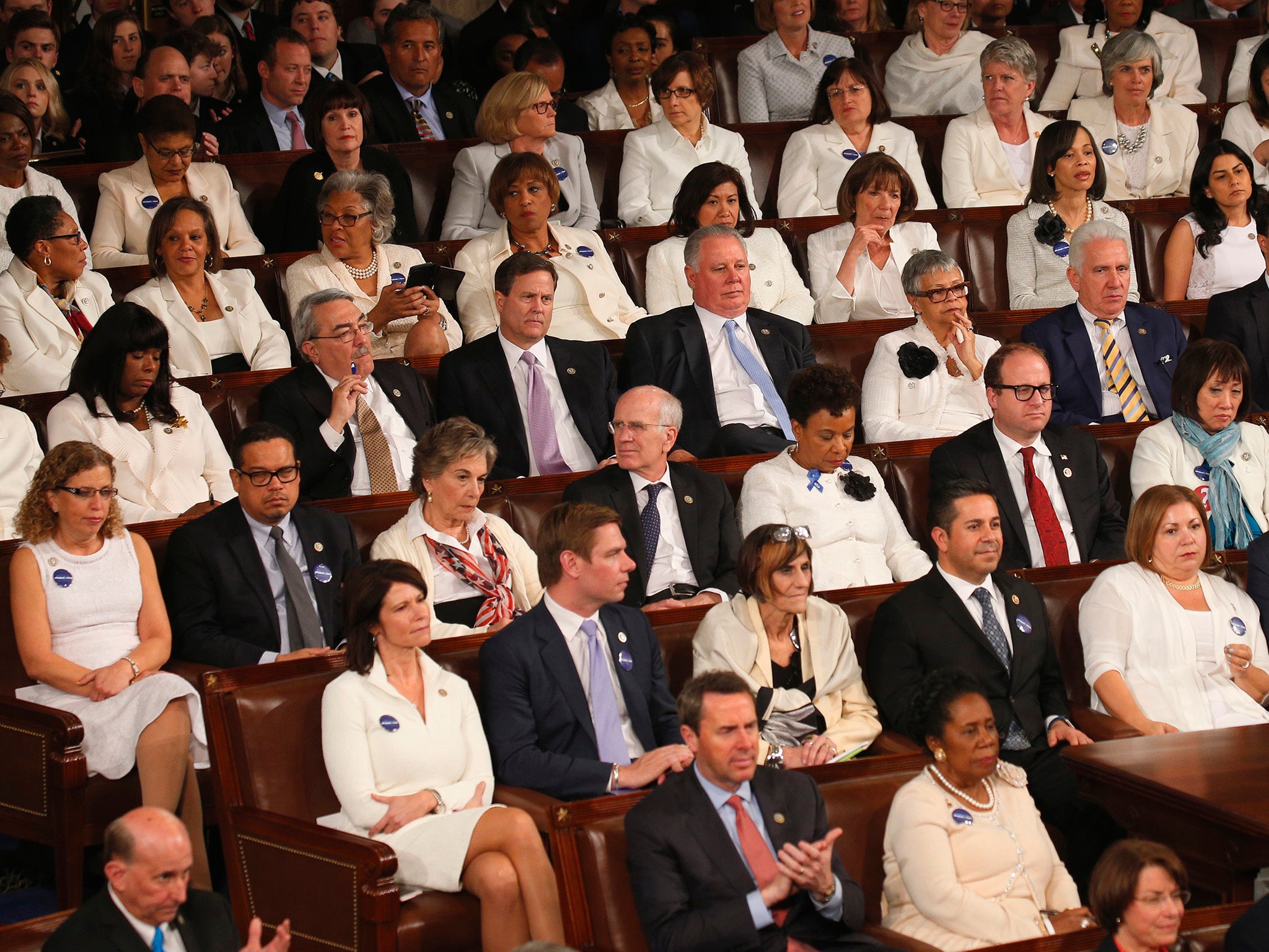 Democratic women in white listen to US President Donald Trump