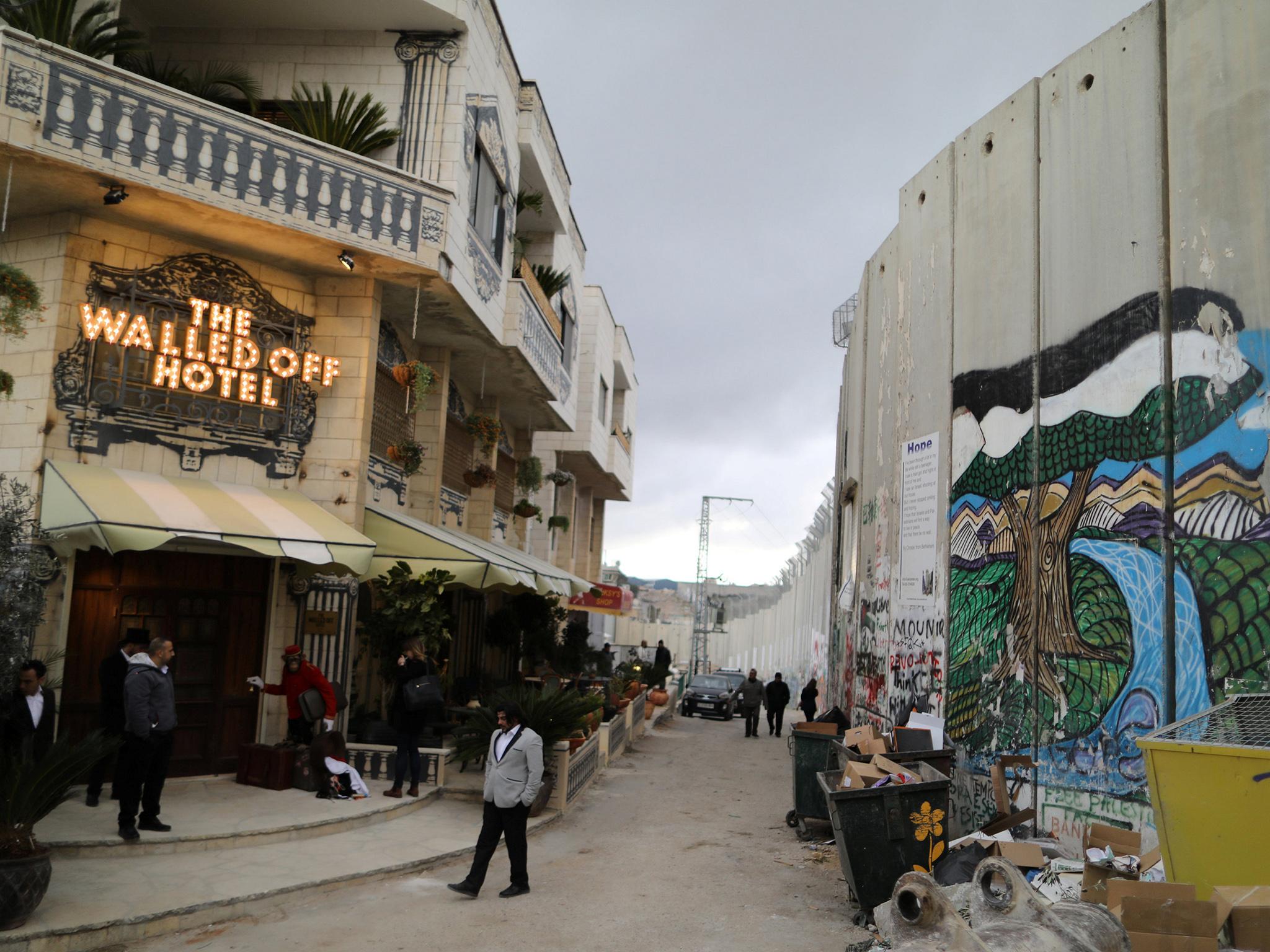 The Israeli separation wall cutting through the West Bank and a settlement illegal under international law can be seen from the rooms of Banksy's new Walled Off hotel in Bethlehem