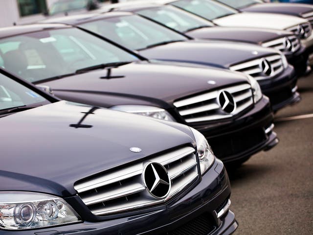 Various Mercedes Benz vehicles in a row at a Mercedes/Smart dealership.   Identical models of Mercedes C-Class vehicles