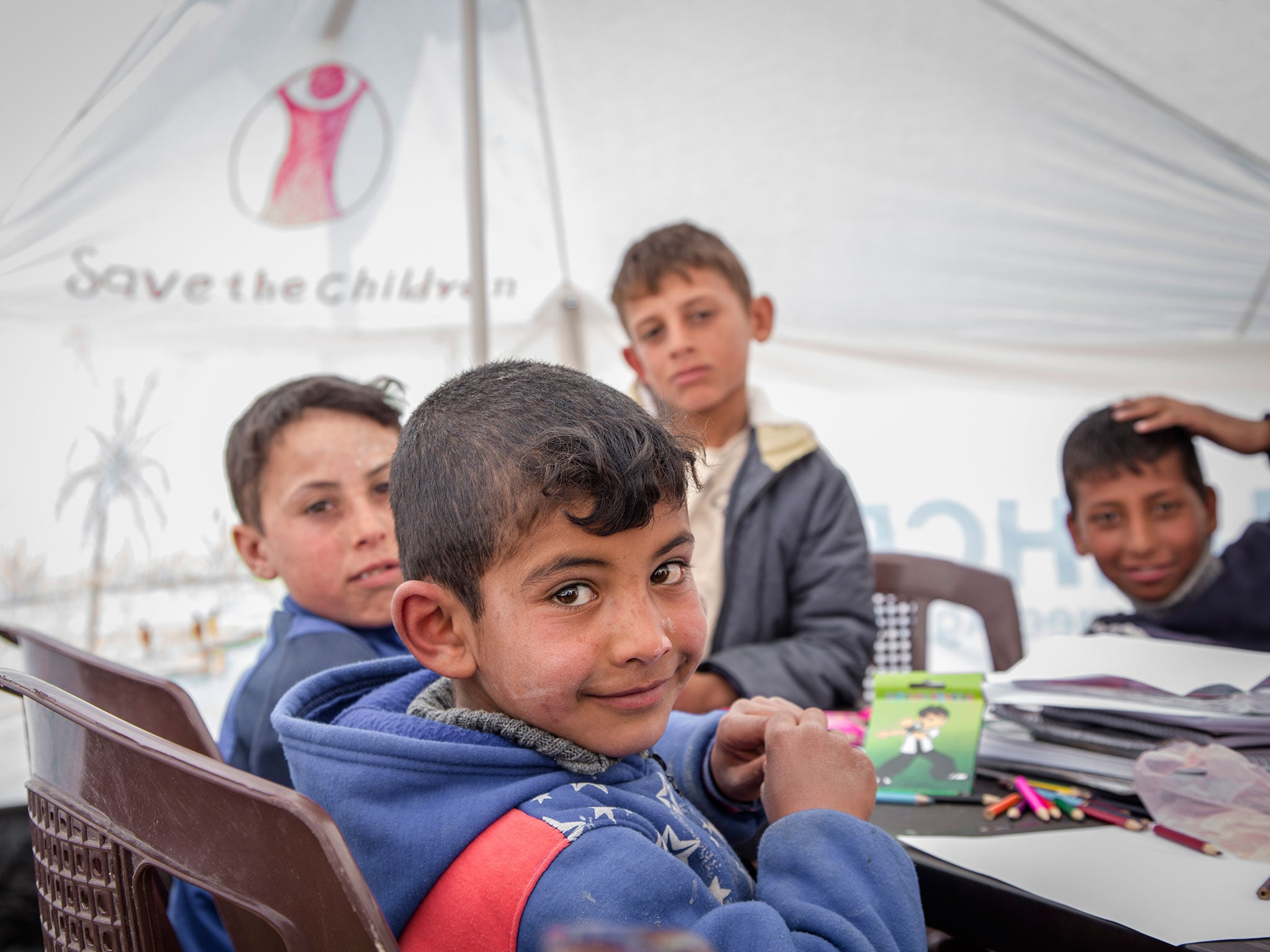 Save the Children runs spaces for children in refugee camps where they can draw, play and listen to music