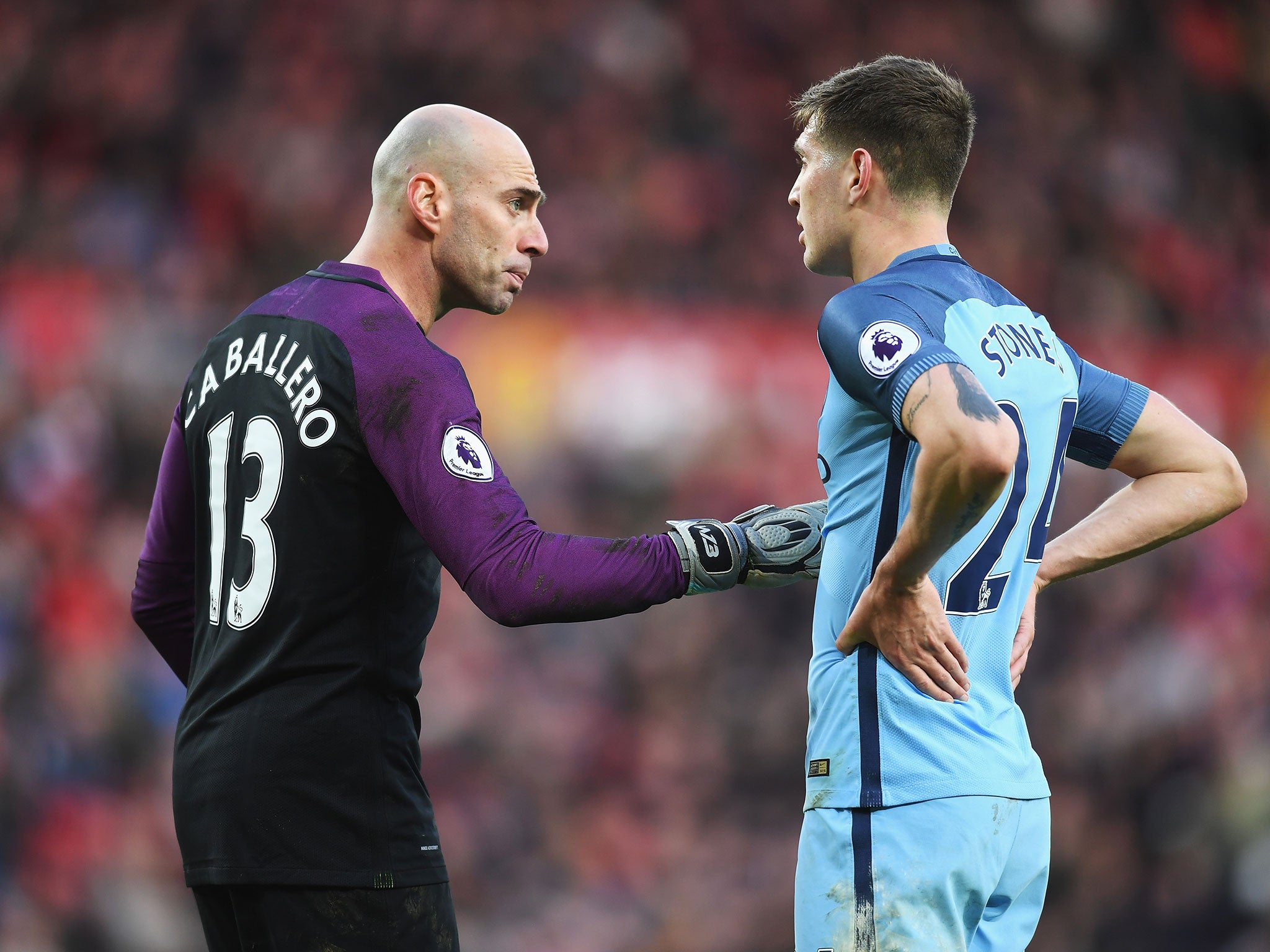 Willy Cabellero talks with John Stones during a pause in play