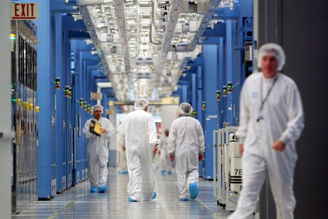 IBM workers walk in an IBM 12-inch wafer chip fabricating plant July 20, 2004 in Fishkill, New York