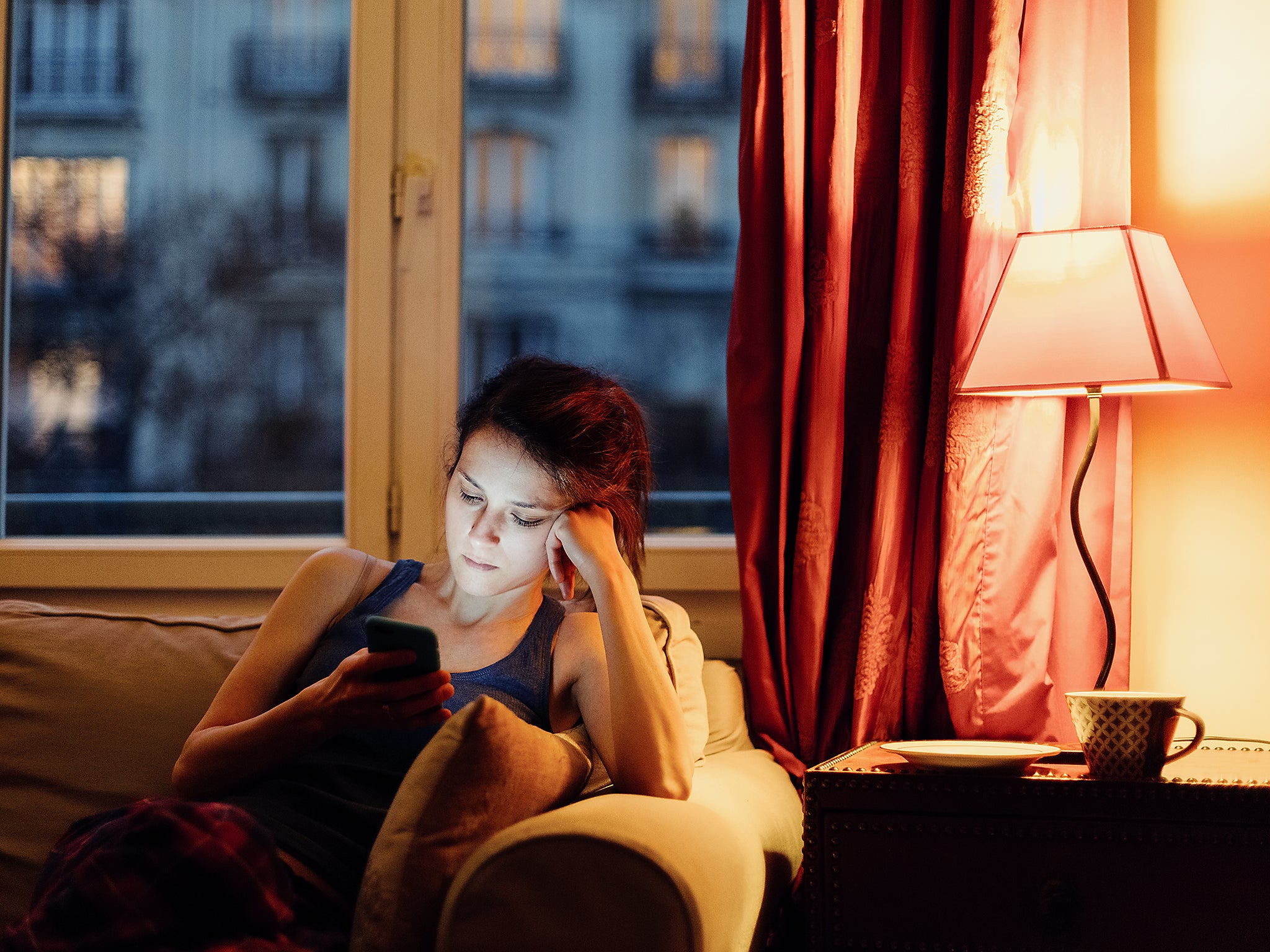 Unhappy woman at home text messaging